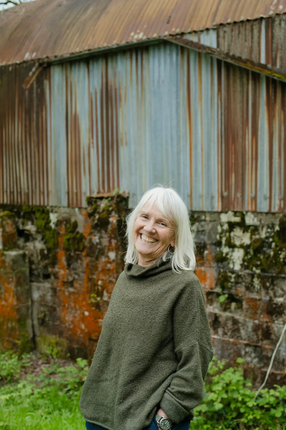 A smiling woman with silver hair outdoors